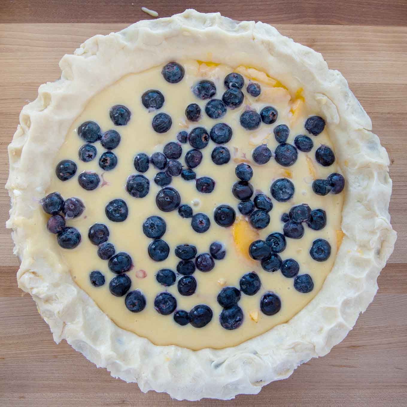 blueberries added to custard filling in the pie crust