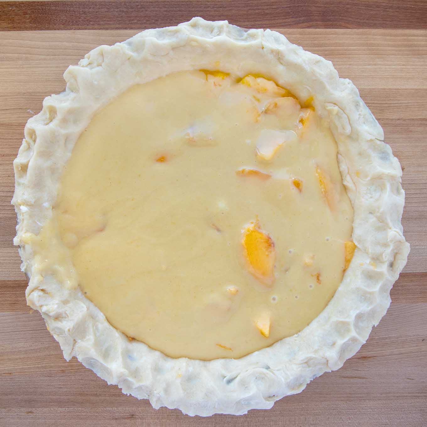 custard over the layer of peaches in an unbaked pie shell