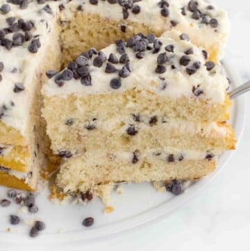 slice of cannoli cake on a spatula being taken out of the whole cake