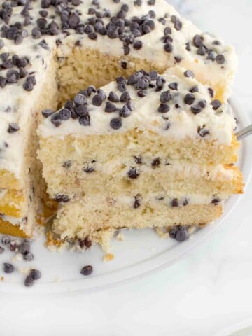 slice of cannoli cake on a spatula being taken out of the whole cake