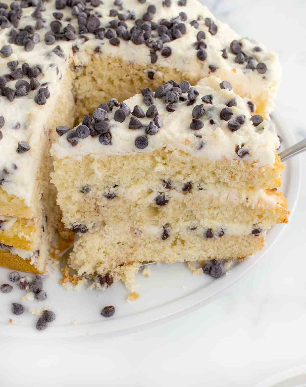 slice of cannoli cake on a spatula being taken out of the whole cake