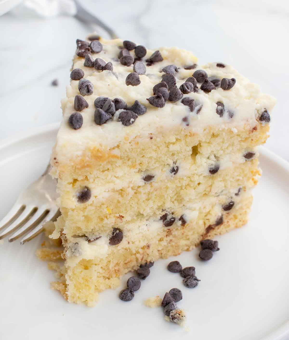 slice of cannoli cream cake on a white plate with a fork