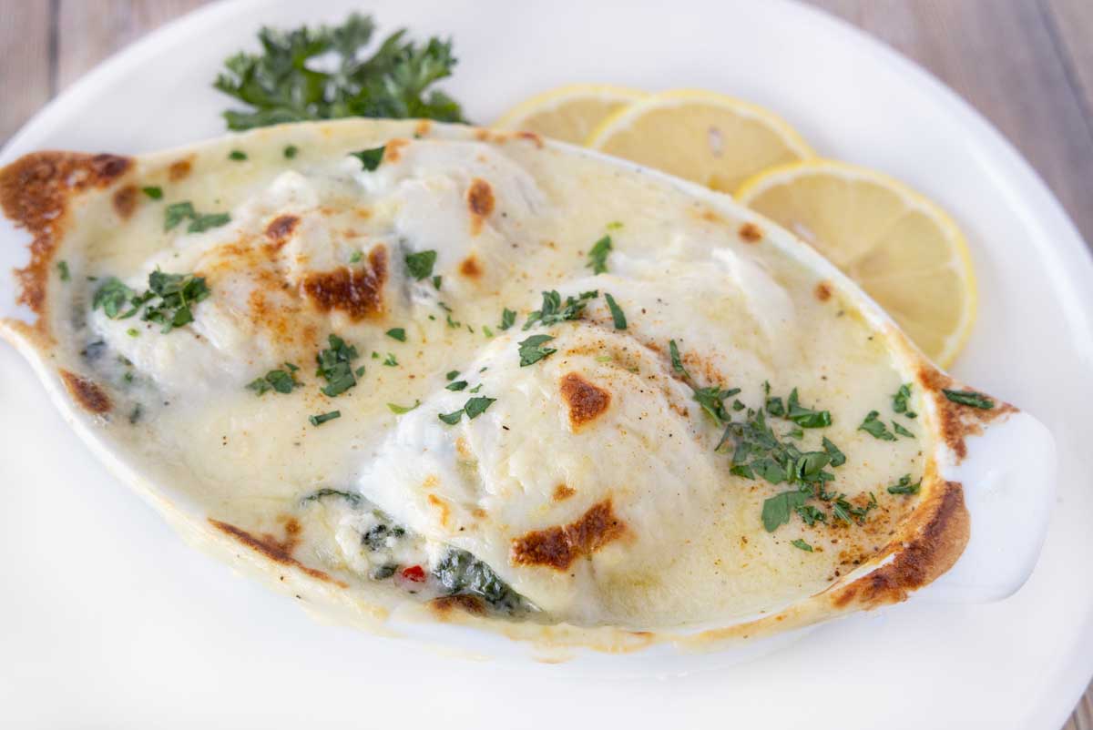 close up of baked stuffed flounder in a white casserole dish