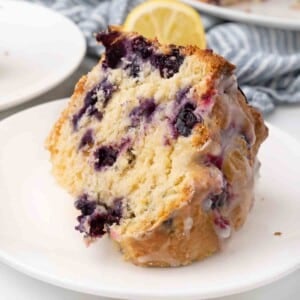 Slice of lemon blueberry pound cake on a white plate.