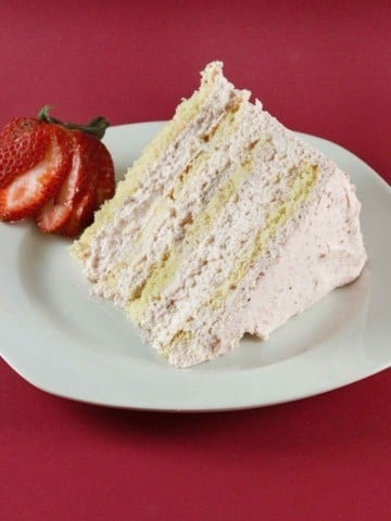 slice of strawberry cream cake on a white plate