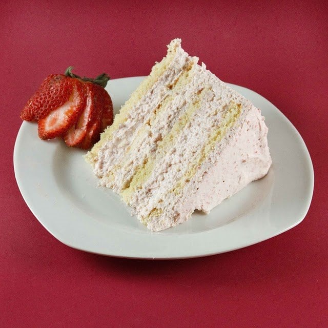 slice of strawberry cream cake on a white plate