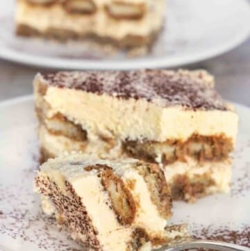 Tiramisu with a fork on a white plate