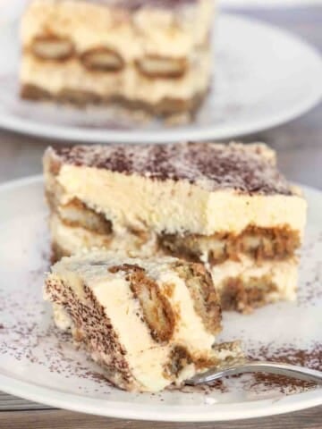 Tiramisu with a fork on a white plate