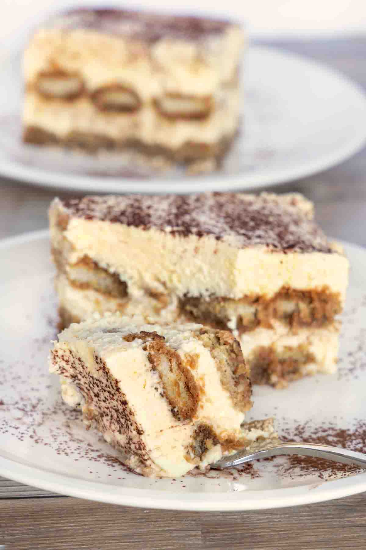 Tiramisu with a fork on a white plate.