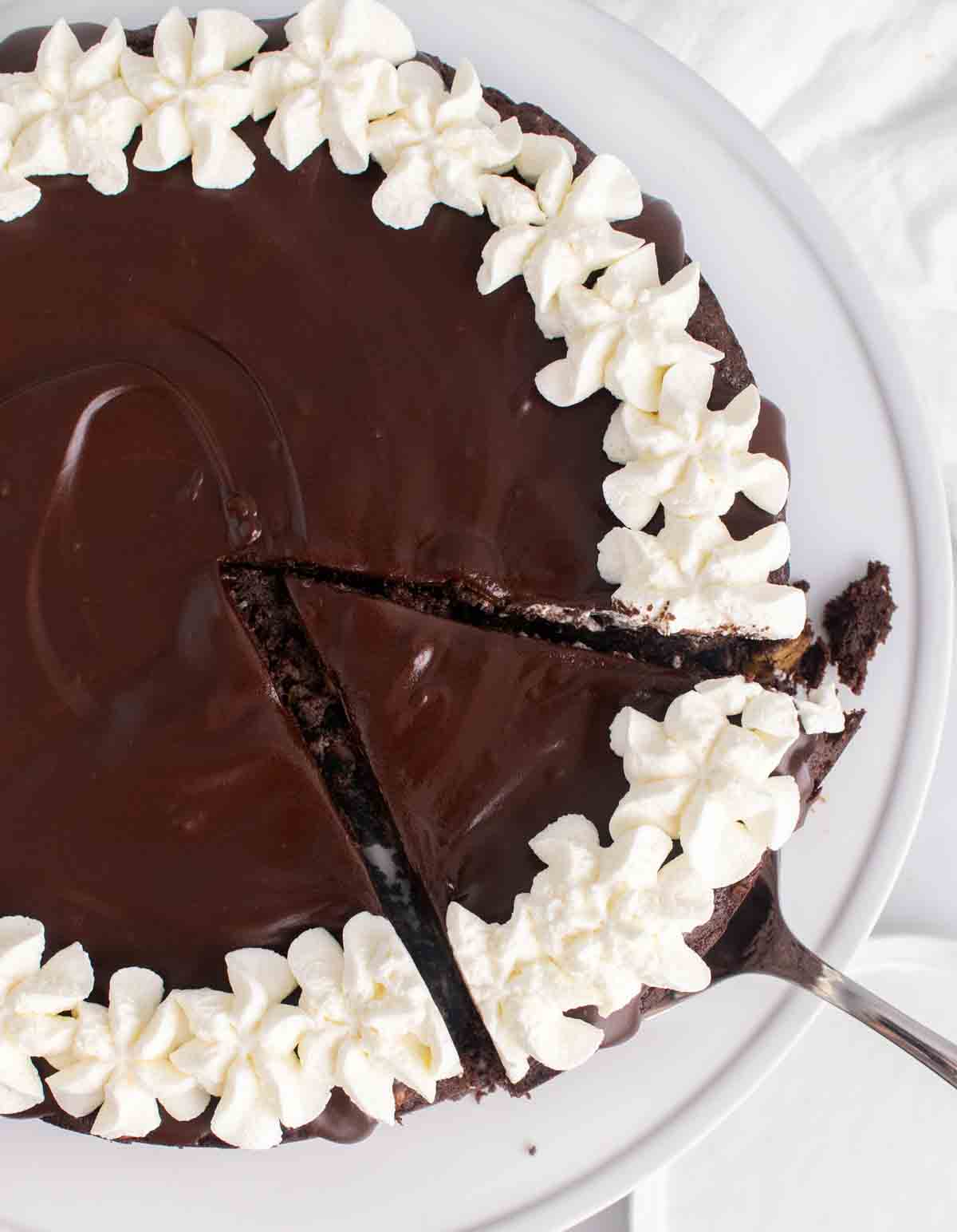 overhead partial view of the whole chocolate torte with a slice being taken out on a spatula