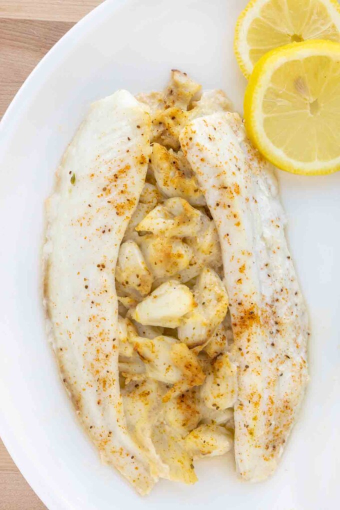 overhead view of stuffed flounder on a white plate with lemon circles