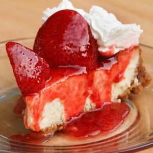 slice of mascarpone cheesecake topped with strawberries and strawberry sauce