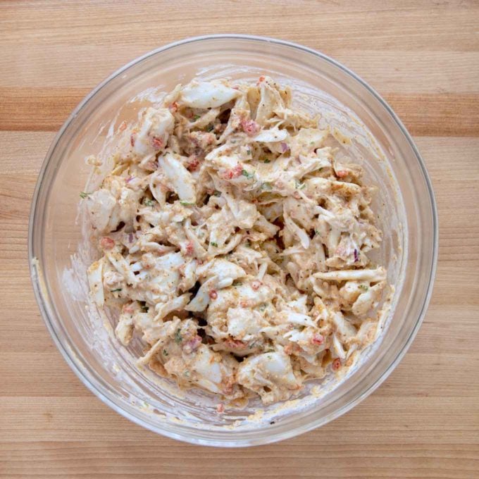 crabcake mixture in a glass bowl on a wooden cutting board