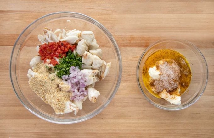 one glass bowl with crabmeat, onion, red pepper, parsley and bread crumbs. Another bowl with the wet ingredients