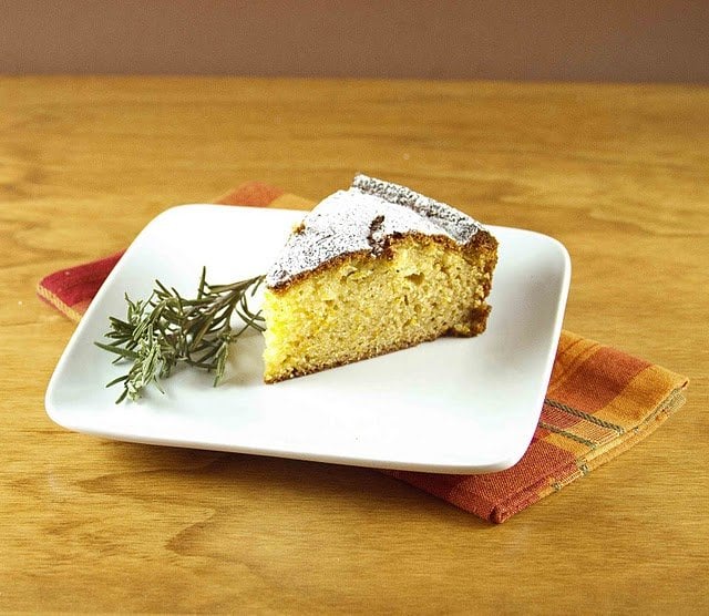 slice of olive oil cake with bunch of rosemary on the side