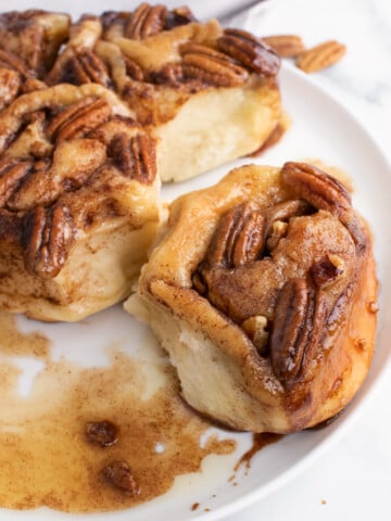 caramel pecan bun being taken out of the group of buns