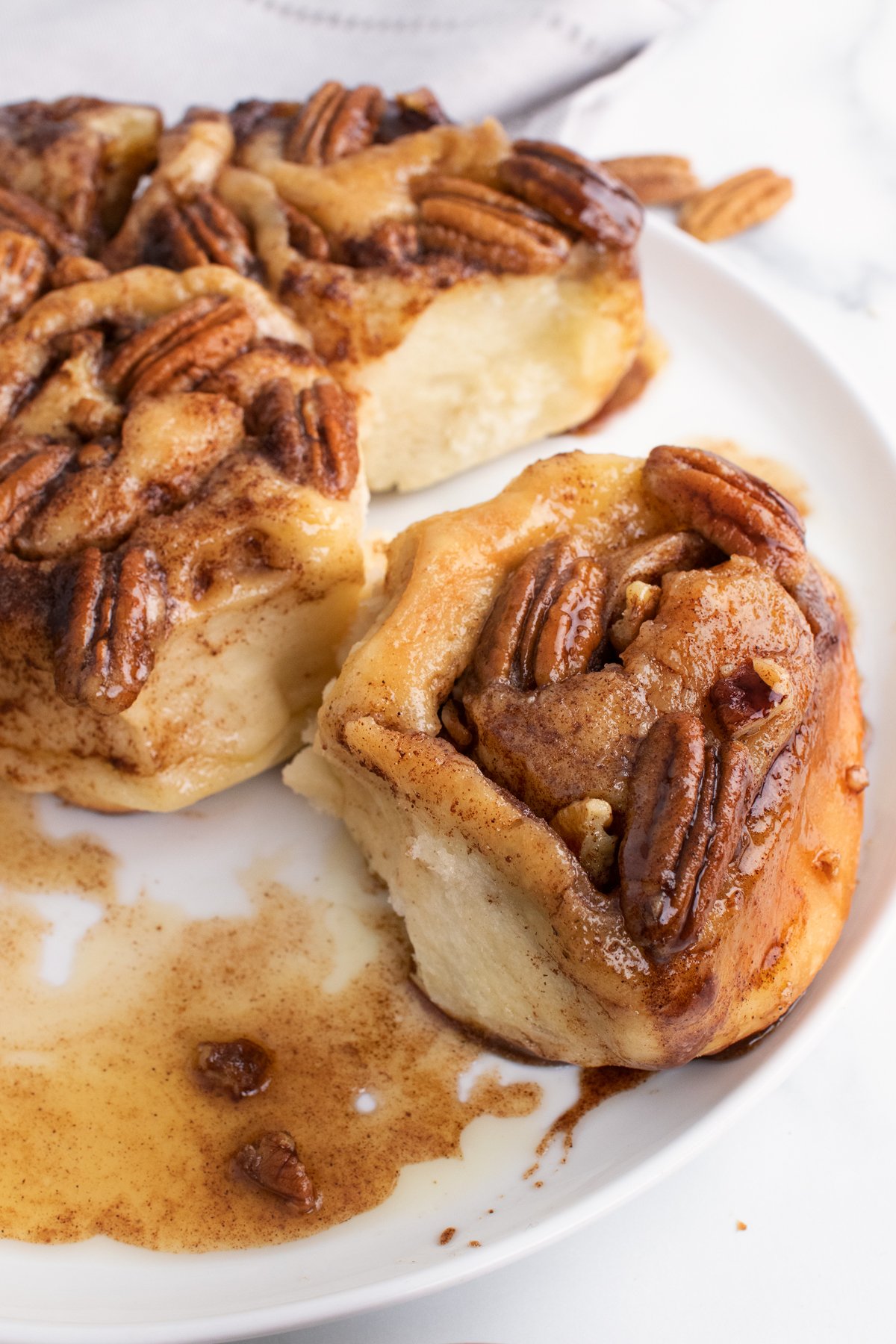 caramel pecan bun being taken out of the group of buns