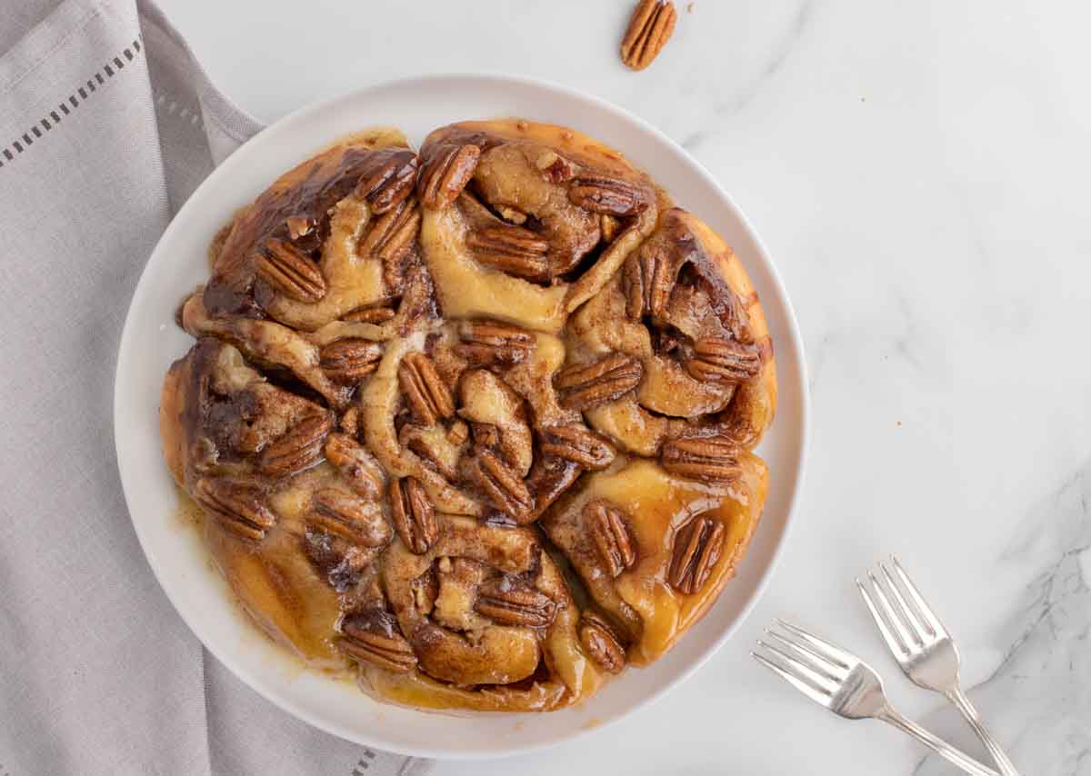 overhead shot of full pan of caramel pecan buns on a white platter