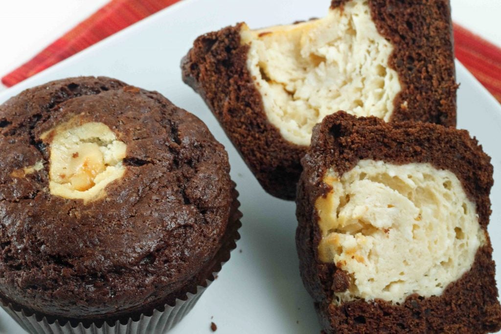 Chocolate and cheesecake muffins sitting on a white plate