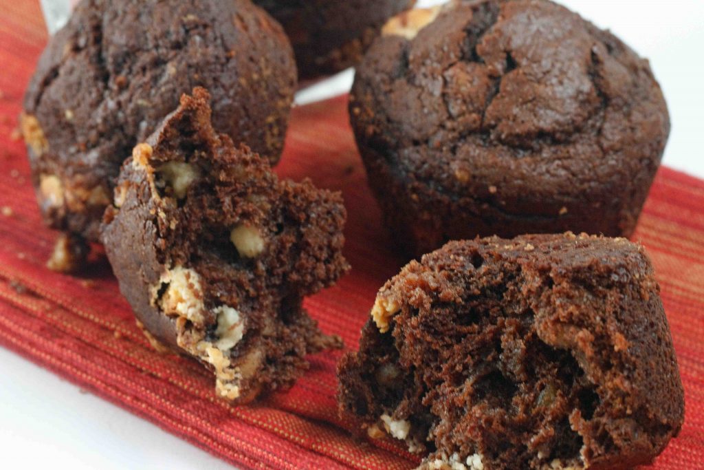 Chocolate brownie muffin, with chocolate chips and walnuts sitting on a red napkin