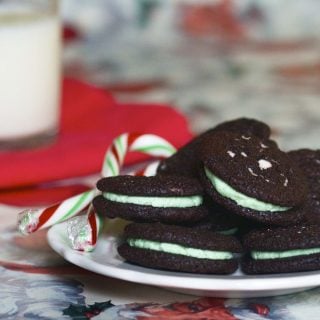 stack of mint oreos on a white plate with a candy cane