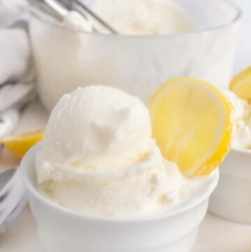 lemon gelato in a bowl with a wedge of lemon