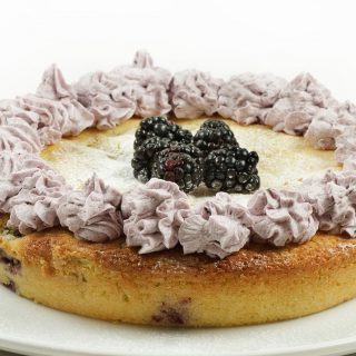 blackberry lime butter cake with blackberry whipped cream and mound of blackberries in the center