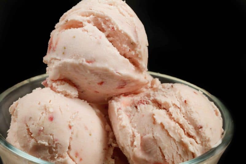 close up of scoops of strawberry ricotta gelato in glass dish 