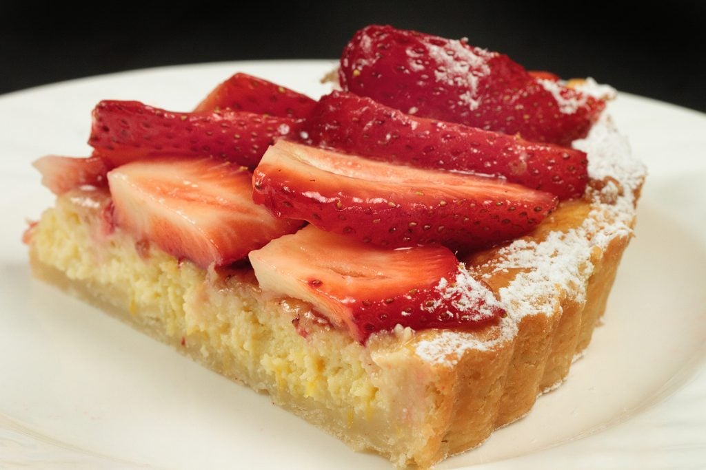 slice of a strawberry ricotta crostata on a white plate