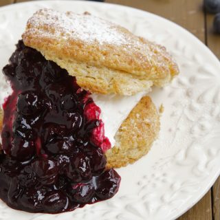 split scone wit blueberry sauce on a white plate