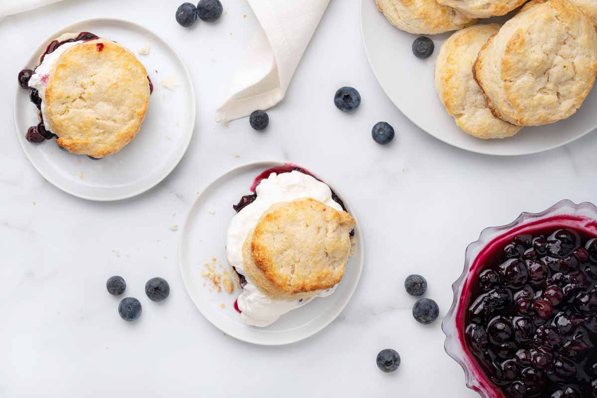 overhead view of scones on plates with blueberry compote in a bowl on the side