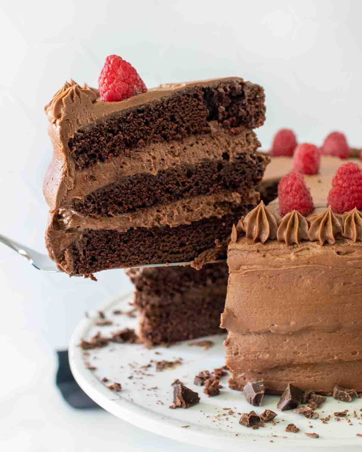 slice of chocolate mousse cake being taken out of whole cake