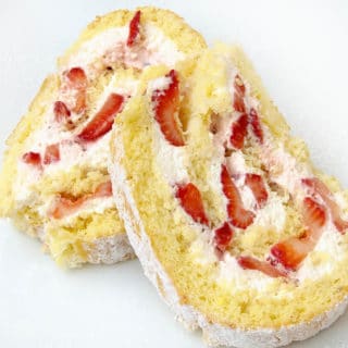 slices of a strawberry shortcake roll on a white plate