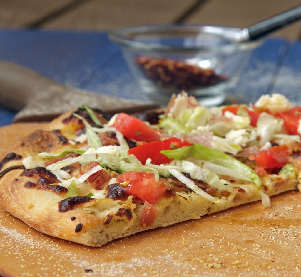 Italian Hoagie Pizza slice of Italian Hoagie Pizza on a pizza peel