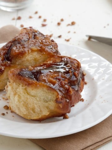 2 pecan sticky buns on a white plate