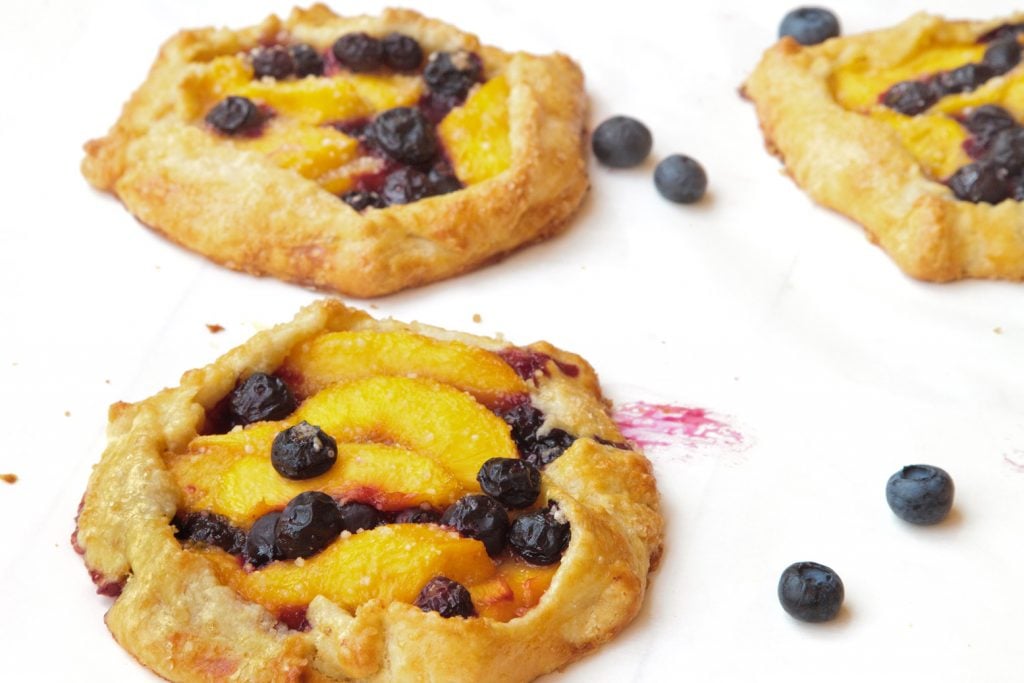 3 blueberry peach crostata on a white tray