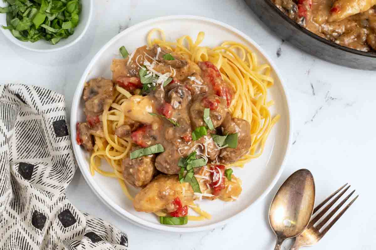 overhead shot of Tuscan chicken and sausage on a white plate 