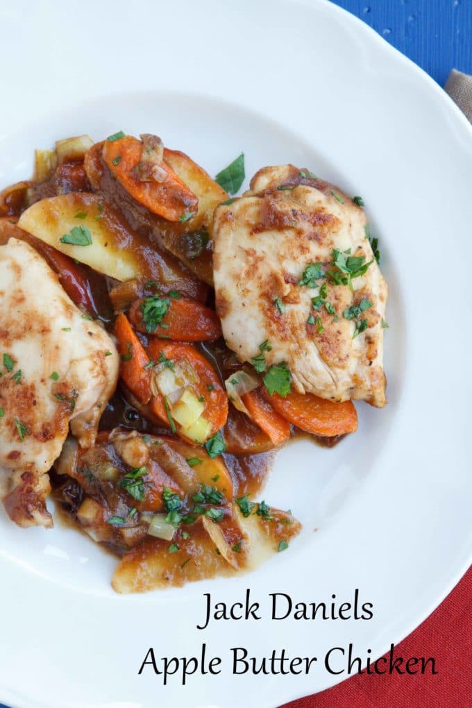 chicken thighs with carrots and apples in a Jack Daniels apple butter sauce sprinkled with parsley on a white plate