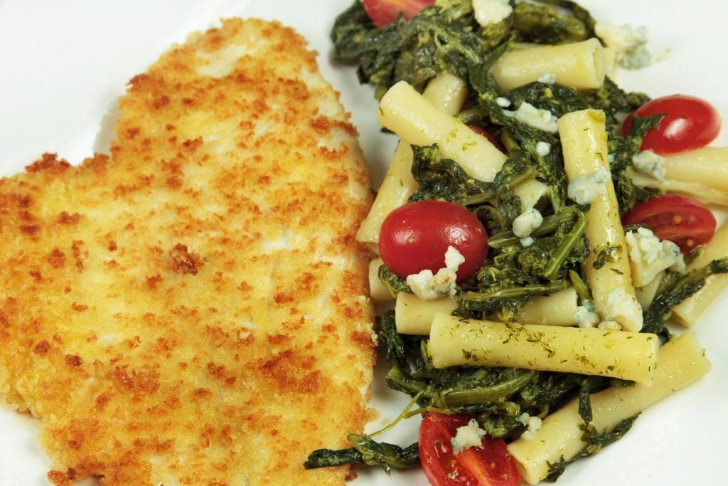 Panko breaded flounder with broccoli rabe pasta on a white plate