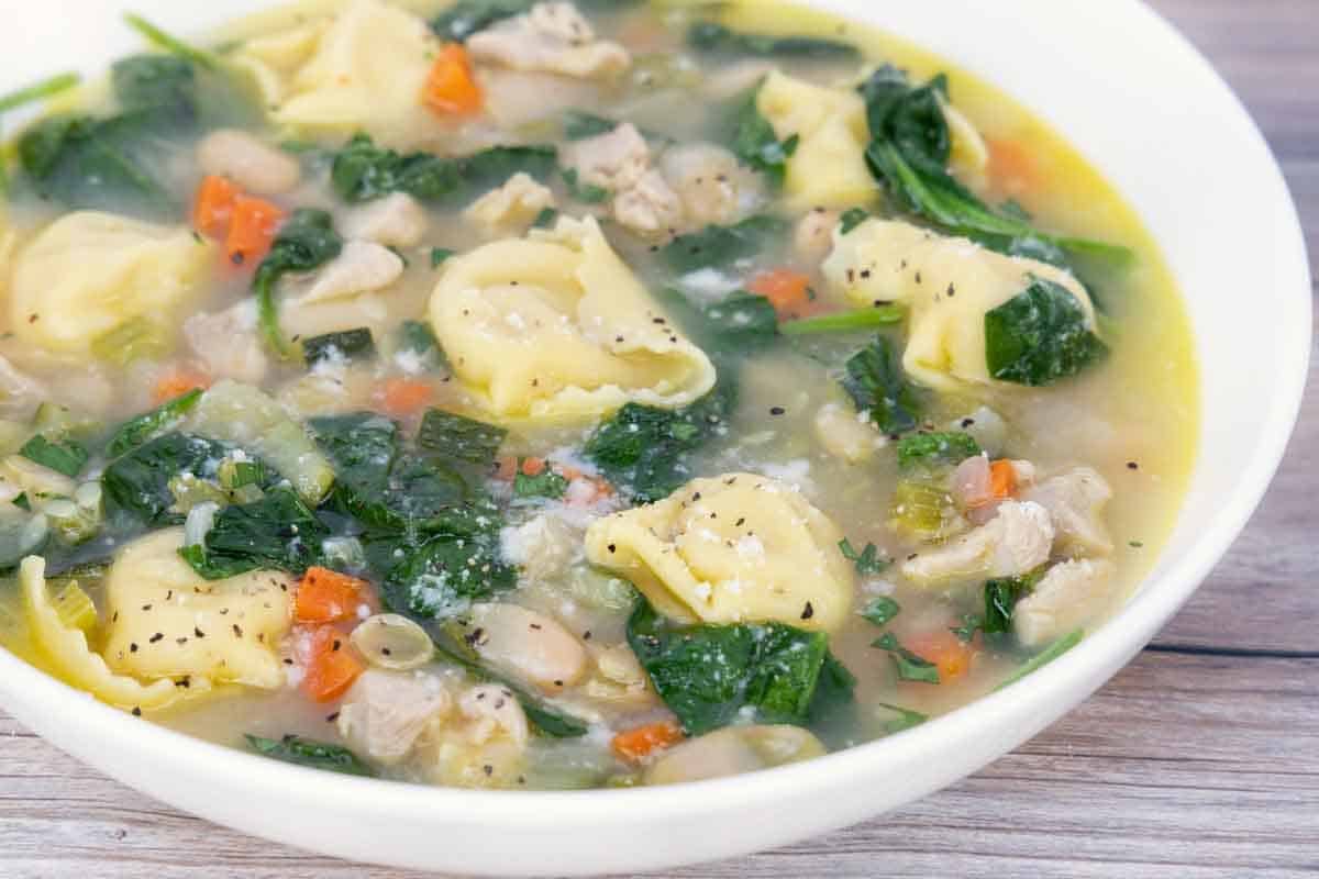 chicken tortellini soup in a white bowl.