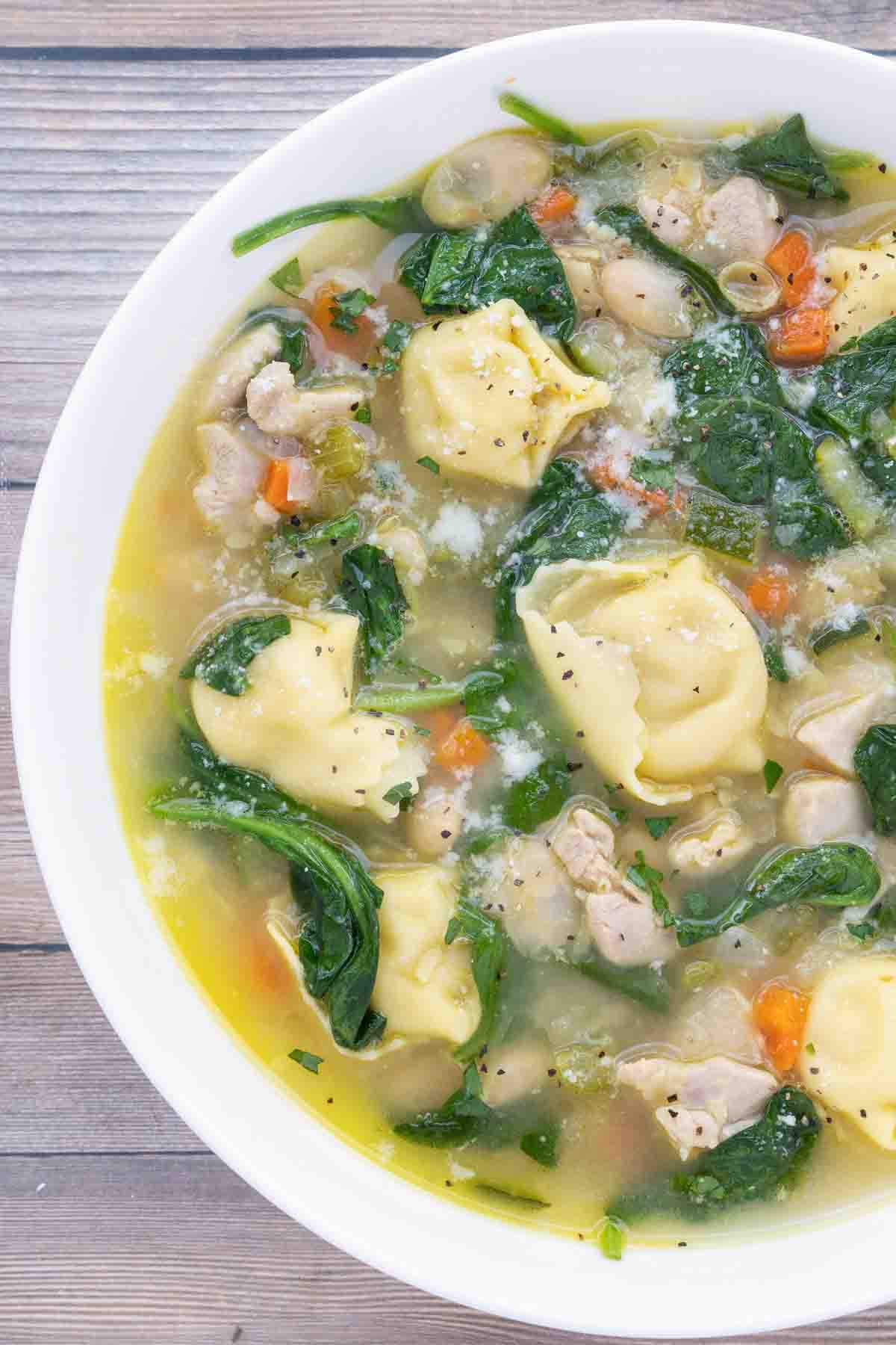 chicken tortellini soup in a white bowl.