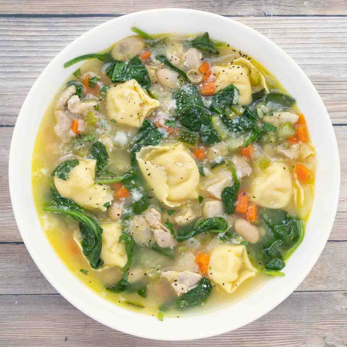 chicken tortellini soup in a white bowl.