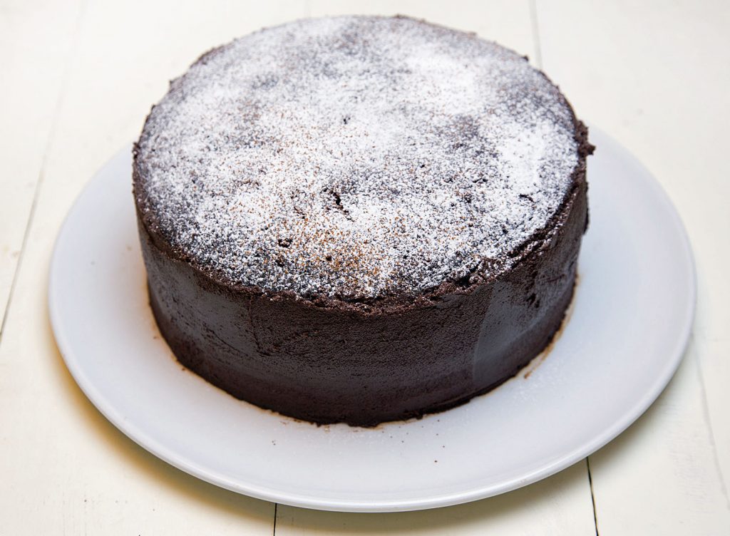 overhead shot of Chocolate Fudge Cake dusted with powdered sugar