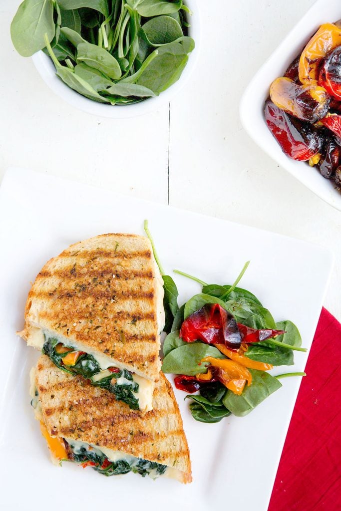 overhead view of Italian Grilled Cheese with partial view of roasted Peppers and Spinach in bowls