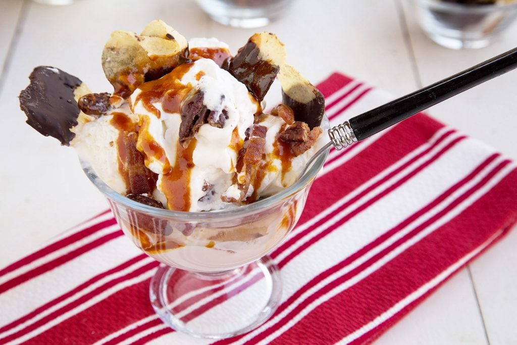 side view of Sundae with Maple Candied Bacon on a red and white striped napkin