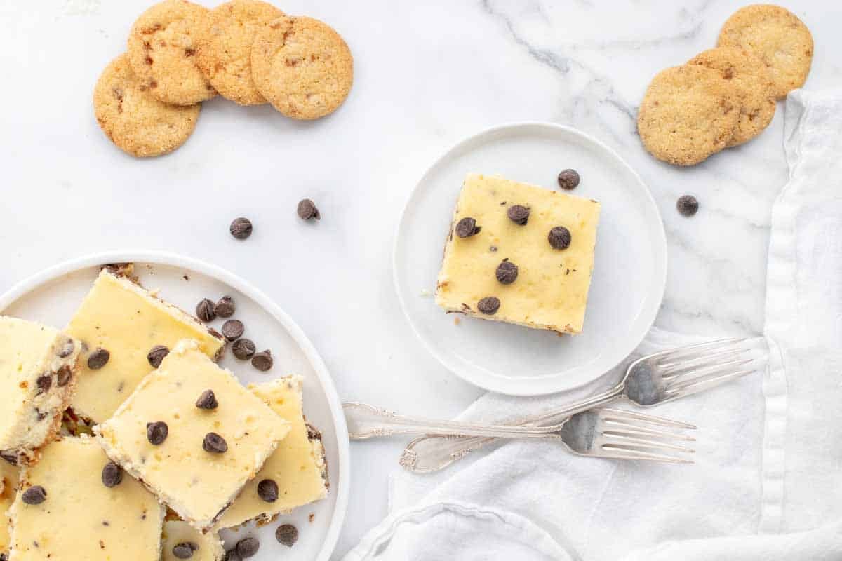 plate of cheesecake bars and one cheesecake bar on a white plate 