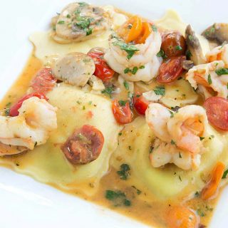 Ricotta and spinach ravioli topped with shrimp in a scampi sauce