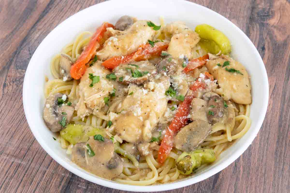 Chicken and Shrimp Toscano Chicken tuscano with pasta in white bowl.