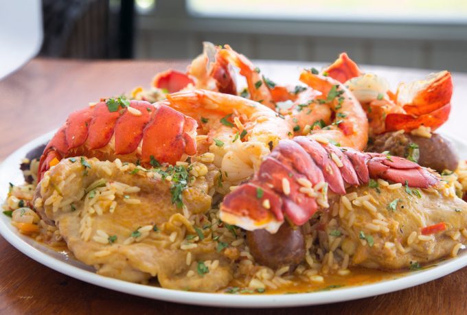 side view of Tex-Mex Jambalaya with split lobster tails on a white platter 