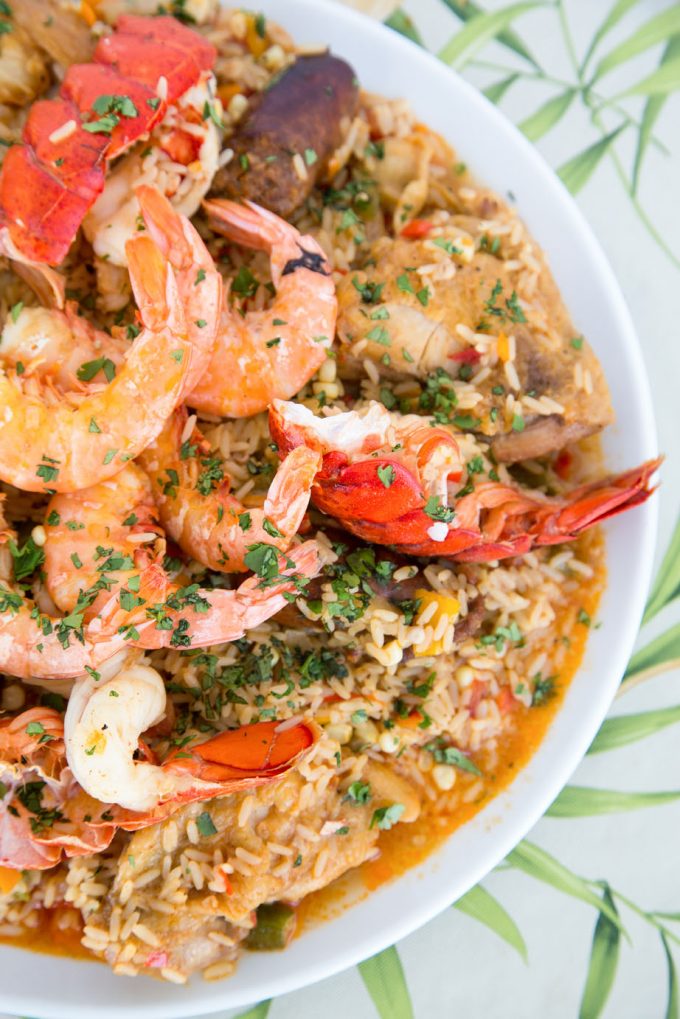 overhead view of Tex-Mex Jambalaya with split lobster tails and shrimp in shells on a white platter 